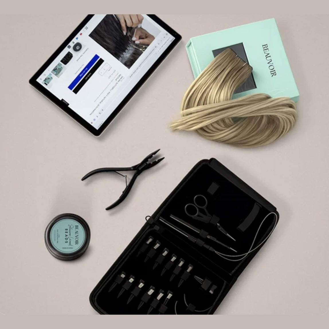 Beauvoir Butterfly Bundle flat lay: butterfly weft in a Beauvoir box, pre-loaded beads, hair extension tool kit and the online Butterfly tutorial on a tablet